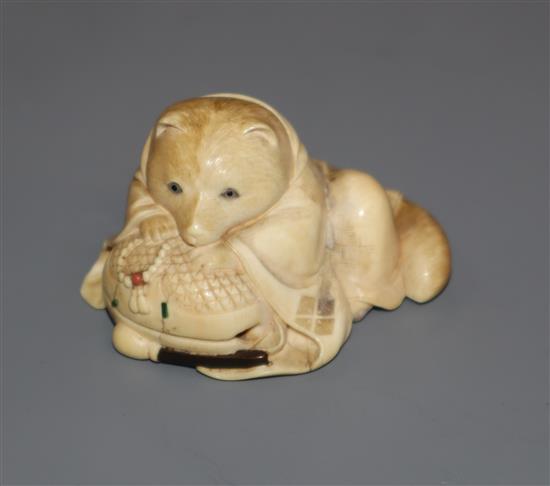 A Japanese Meiji period carved ivory netsuke of a fox cub on a cushion, with inset eyes 3.5cm high